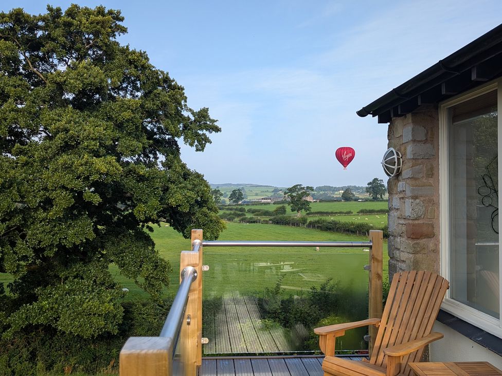 A balcony view with a hot air balloon in the sky at High View Meadows in Kirkby Lonsdale
