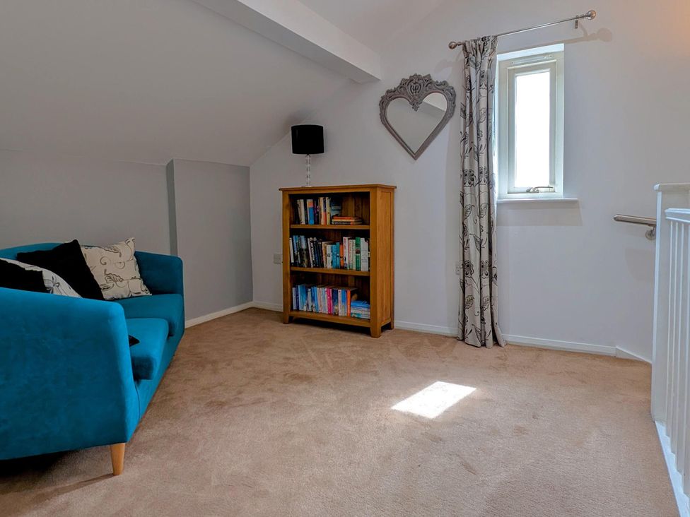 A snug with a bookshelf and a window at High View Meadows in Kirkby Lonsdale