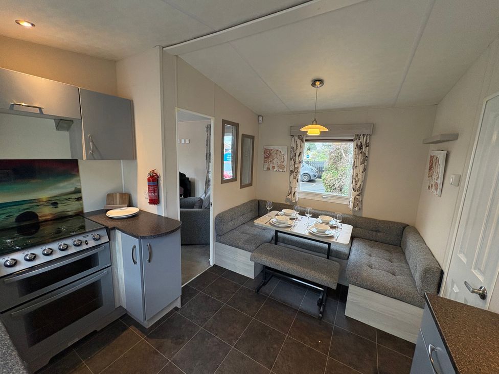 A kitchen with a stove and seating area at Caravan 941 in Clacton-On-Sea