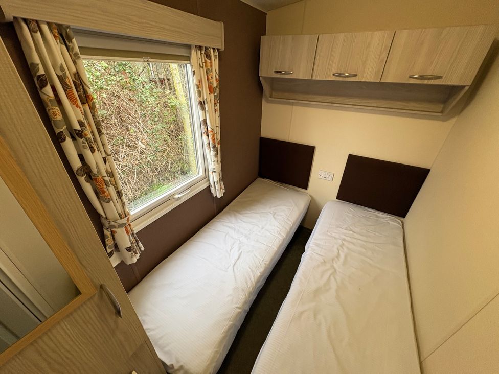 A bedroom with two single beds and a window at Caravan 941 Clacton-On-Sea