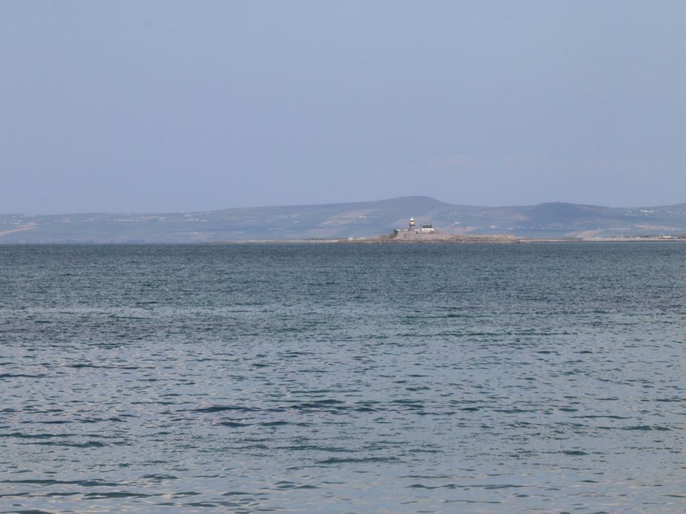 A body of water with a small island and lighthouse in the distance with hills in the background at Killelton Cottage Camp County Kerry