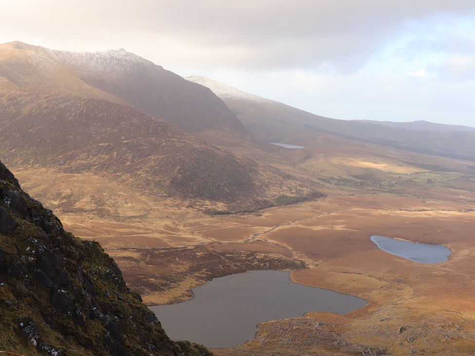 A mountainous landscape with lakes and a partly cloudy sky at Killelton Cottage in Camp County Kerry