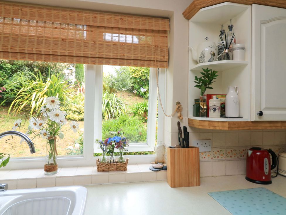 A kitchen with window and flowers on the counter at 3 Chantry Hill in Kingsbridge
