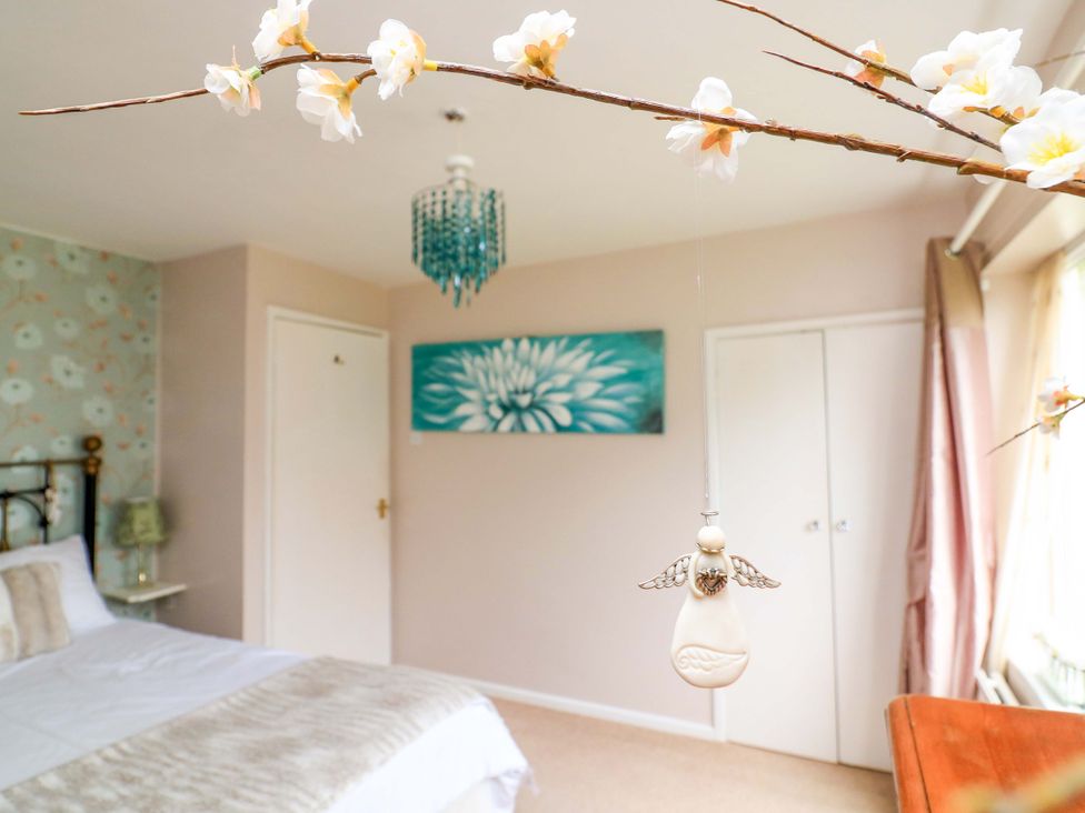 A bedroom with a bed and wall art at 3 Chantry Hill in Kingsbridge