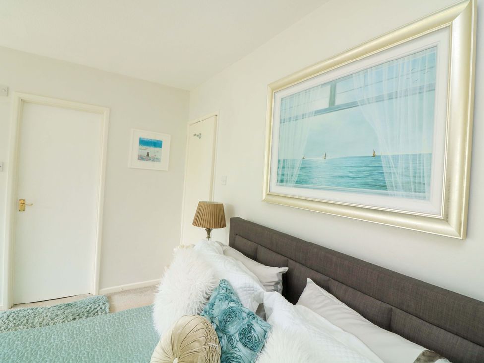 A bedroom with a bed and framed picture at 3 Chantry Hill in Kingsbridge