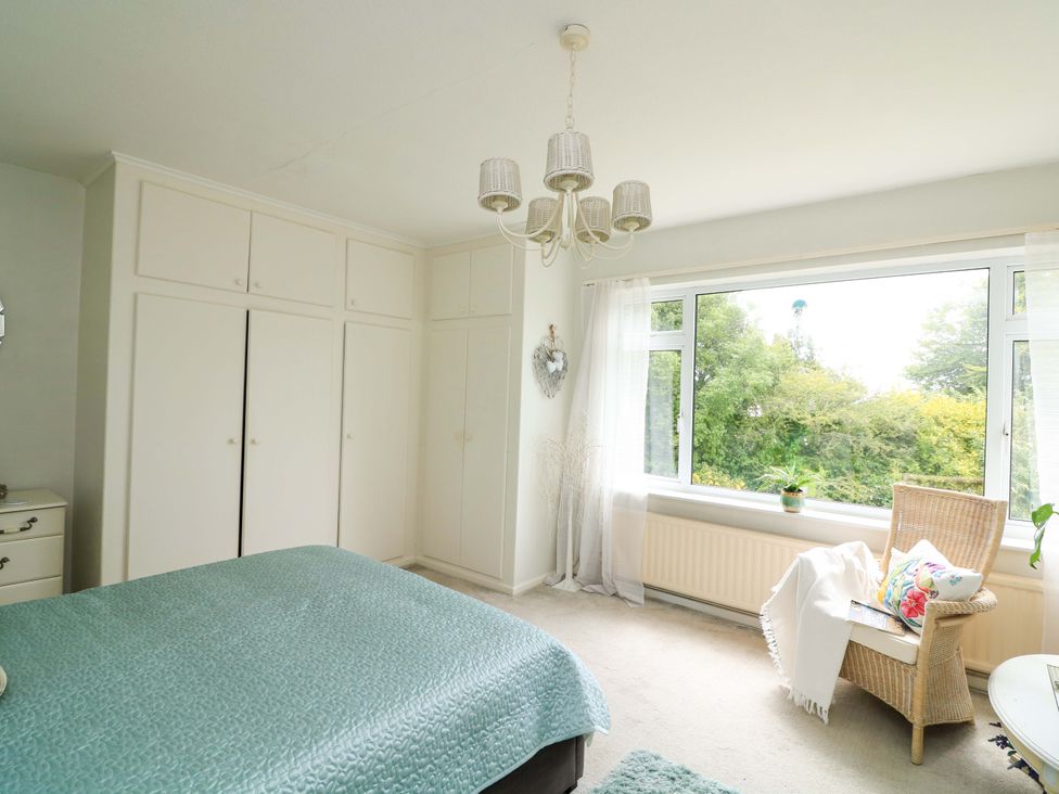 A bedroom with a bed and a chair at 3 Chantry Hill in Kingsbridge