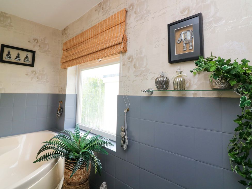 A bathroom with a bath tub and decorative items at 3 Chantry Hill in Kingsbridge