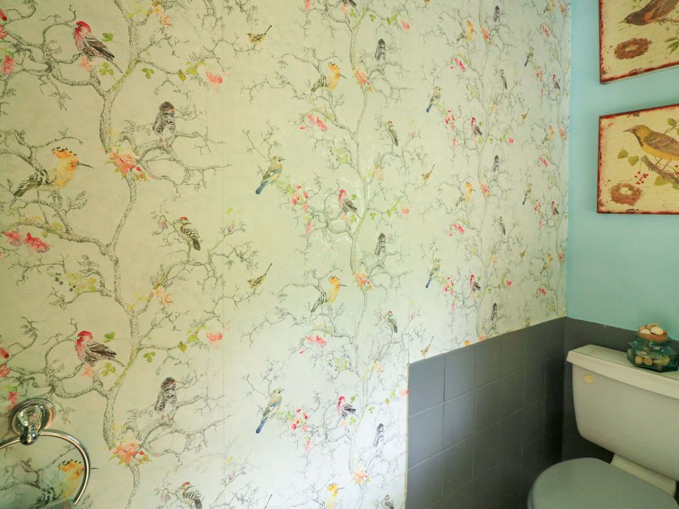 A bathroom with floral wallpaper and a toilet at 3 Chantry Hill in Kingsbridge