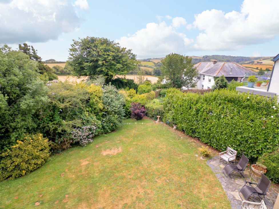 A garden with trees, bushes, and patio furniture at 3 Chantry Hill in Kingsbridge