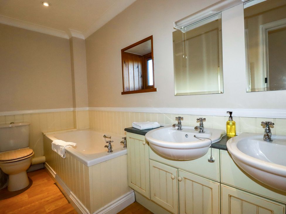 A bathroom with a bathtub, sink, and toilet at The Coach House in Falmouth
