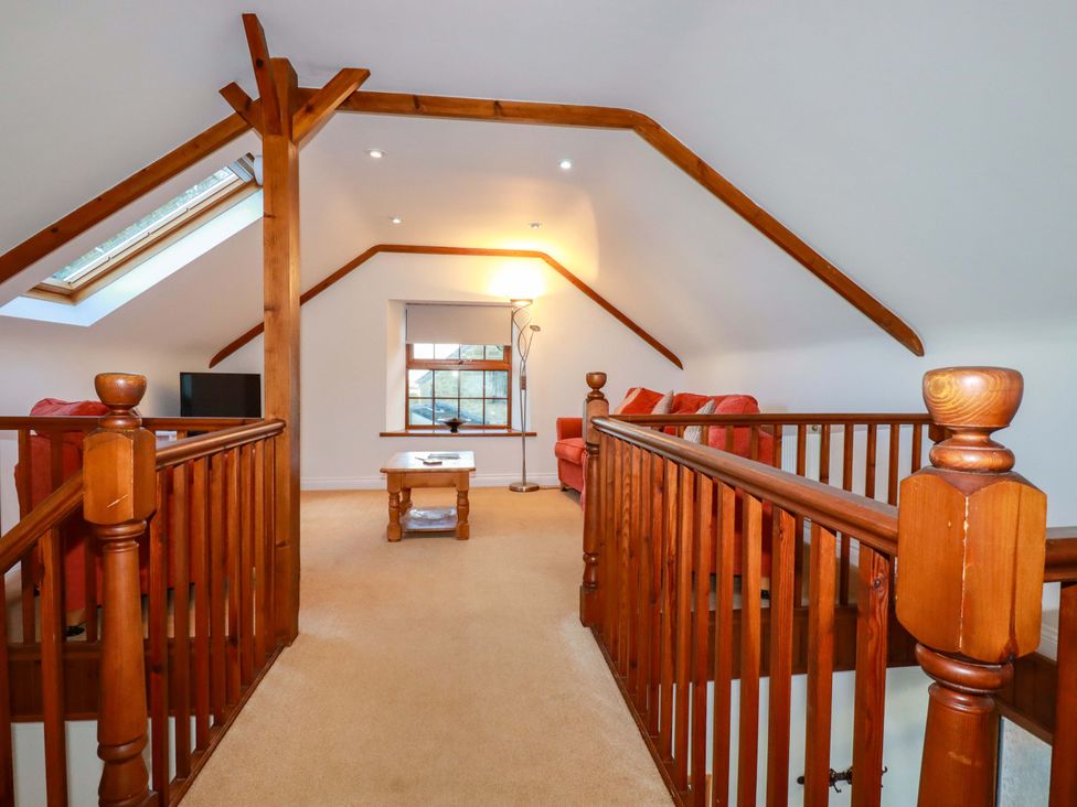 A snug with a sofa and television at The Coach House in Falmouth