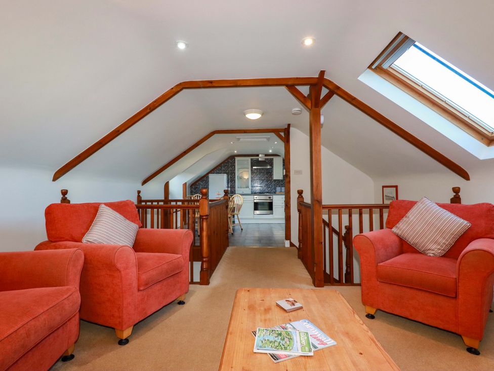 A living room with sofas and a coffee table at The Coach House in Falmouth