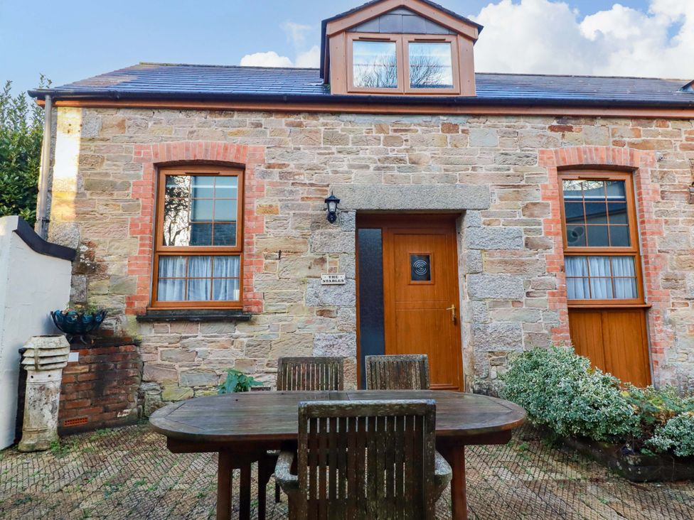 An outdoor area with a table and chairs at The Coach House in Falmouth