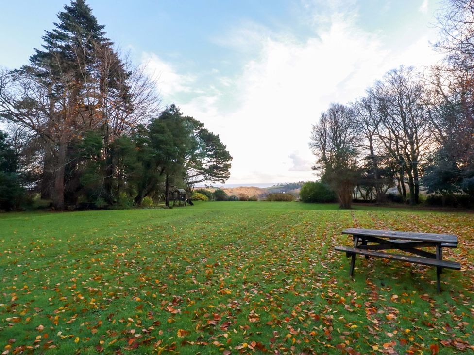 A garden with trees and a picnic table at The Coach House in Falmouth
