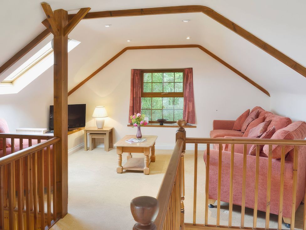 A sitting room with a television and sofa at The Coach House Budock Water near Falmouth