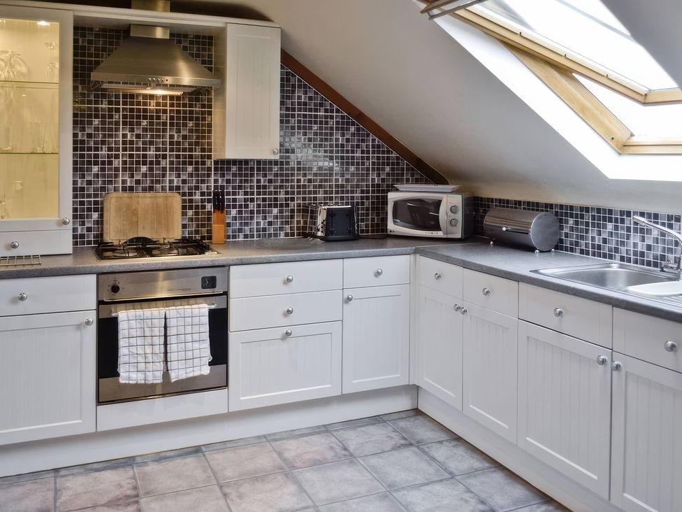 A kitchen with cabinets and appliances at The Coach House in Budock Water near Falmouth