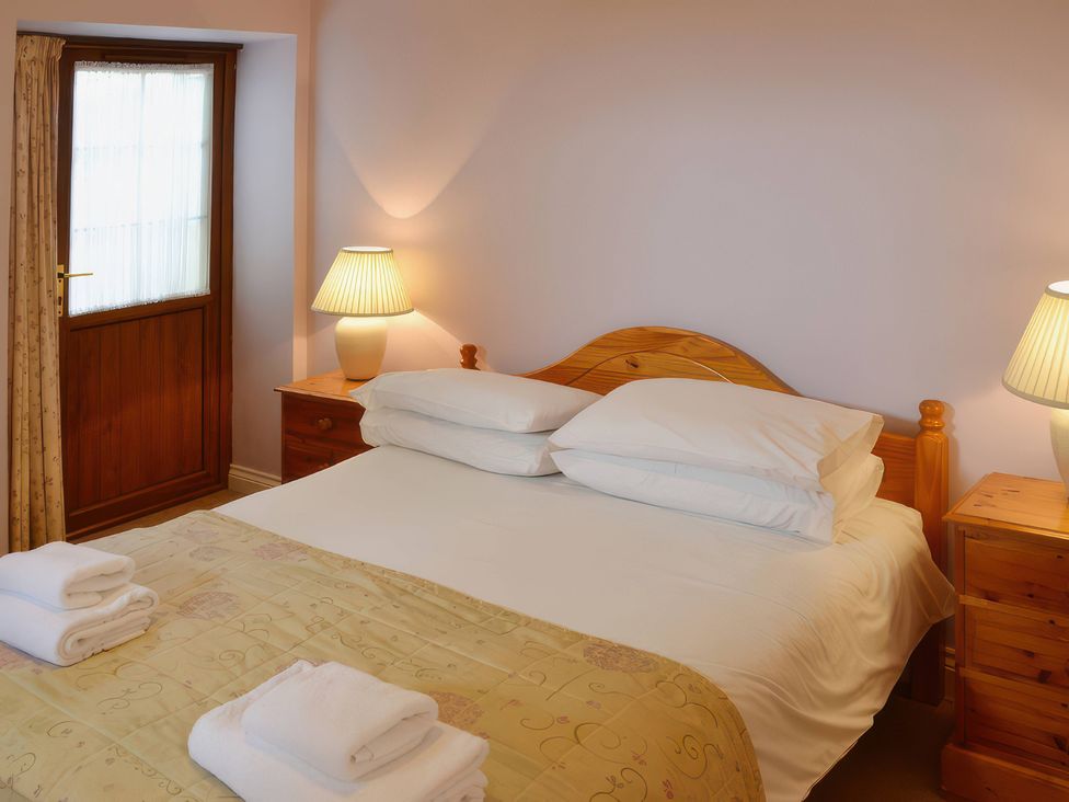 A bedroom with a bed and lamps at The Coach House Budock Water near Falmouth