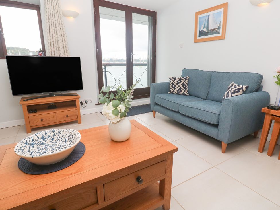 A living room with a sofa and tv stand at Tobys Quay in Falmouth