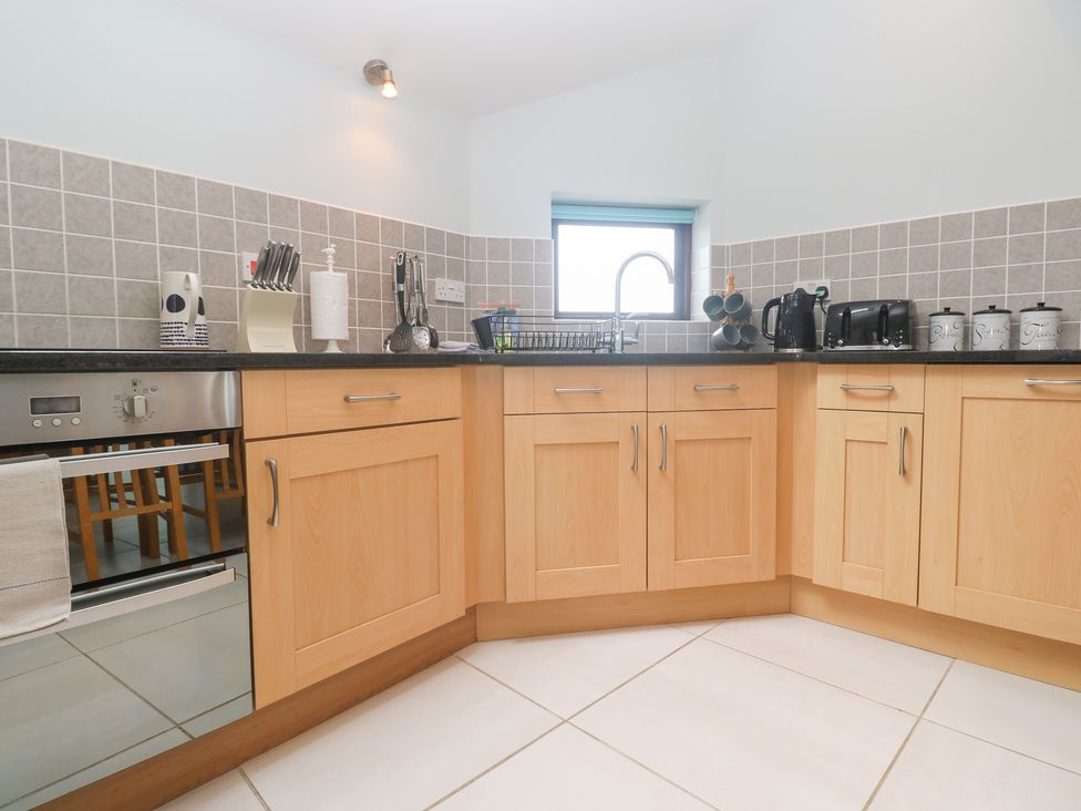 A kitchen with cabinets and appliances at Tobys Quay in Falmouth