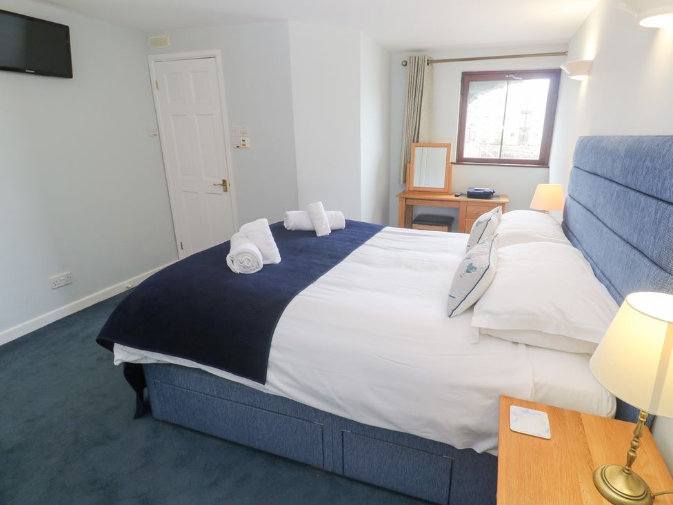 A bedroom with a bed and a desk at Tobys Quay in Falmouth
