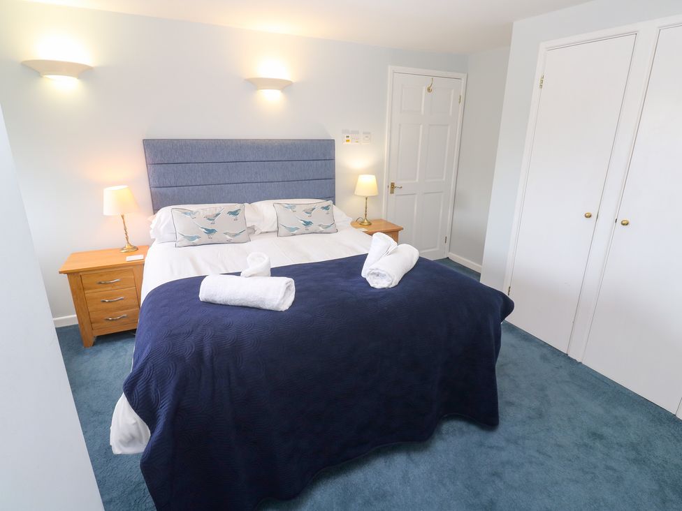 A bedroom with a bed and bedside lamp at Tobys Quay in Falmouth