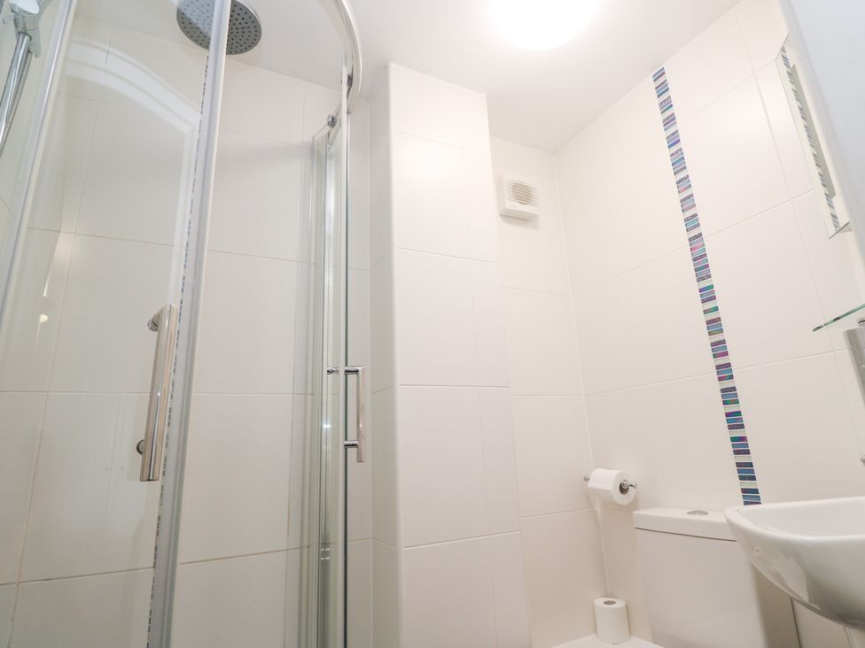 A shower and toilet in a bathroom at Tobys Quay in Falmouth