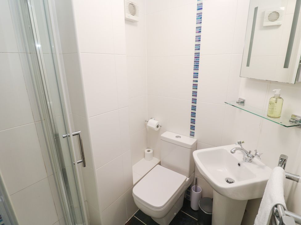 A bathroom featuring a shower, toilet, and sink at Tobys Quay in Falmouth