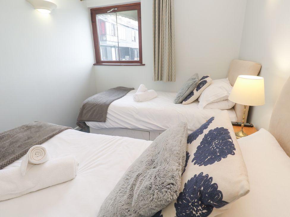 A bedroom with two beds and a lamp at Tobys Quay in Falmouth
