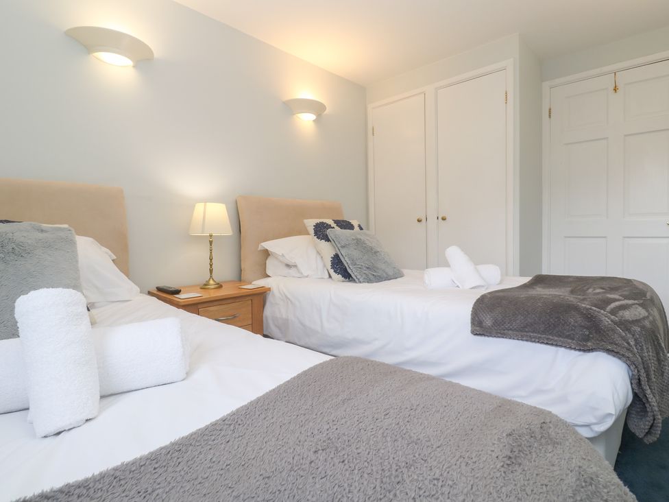 A bedroom with two beds and a bedside table at Tobys Quay in Falmouth
