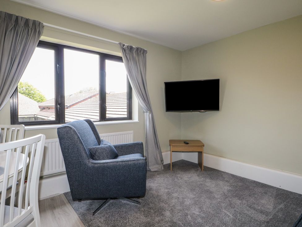 A living room with a chair and television at Flat 1 in Littlehampton