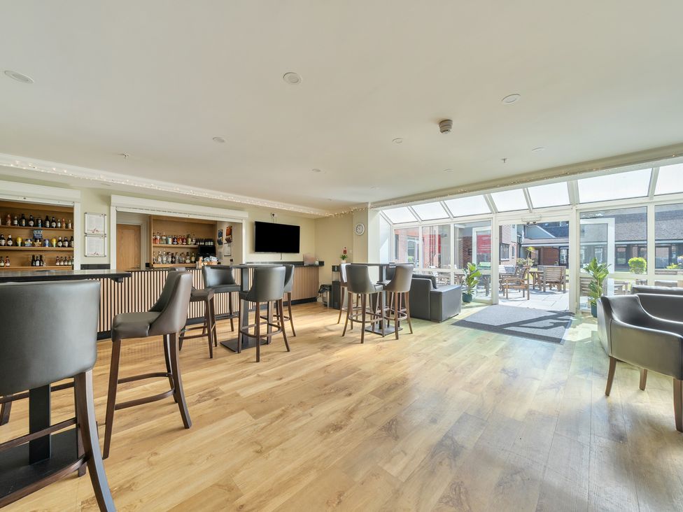 A bar area with stools and a counter at Marine Court Three Bedroom First-floor Apartment Littlehampton