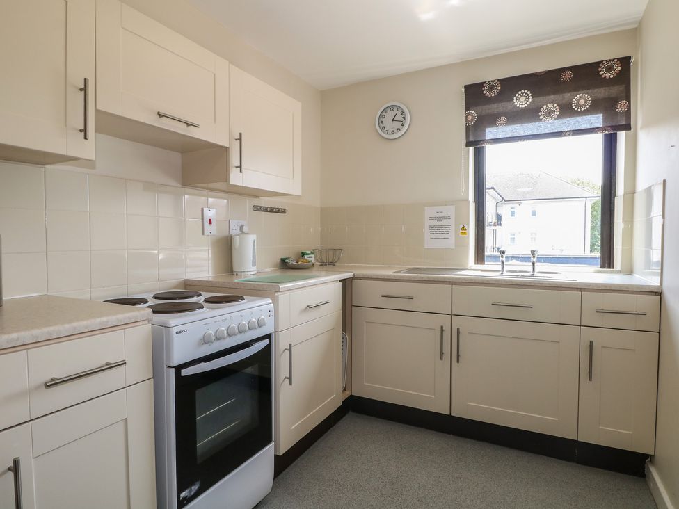 A kitchen featuring a stove, sink, and window at Flat 2 in Littlehampton