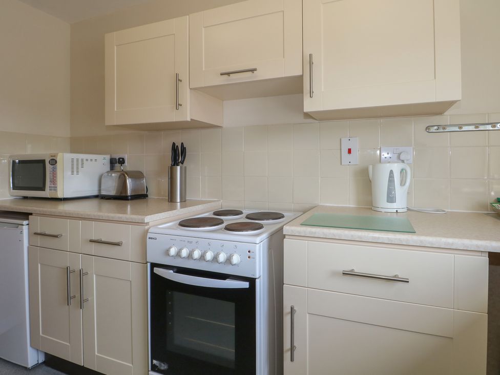 A kitchen with appliances and cabinets at Flat 2 in Littlehampton