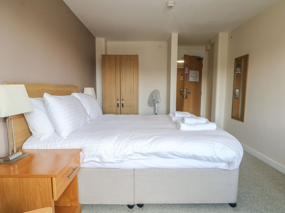 A bedroom with a bed, wardrobe, and lamp at Flat 2 in Littlehampton