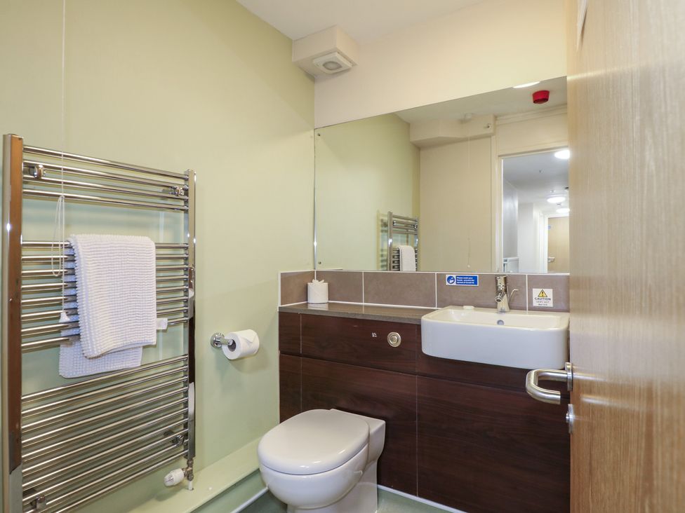 A bathroom with a sink, toilet, and towel rack at Flat 2 Littlehampton