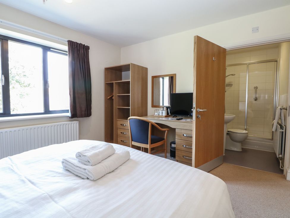 A bedroom with a bed, desk, and an en-suite bathroom at Bedroom 9 in Littlehampton