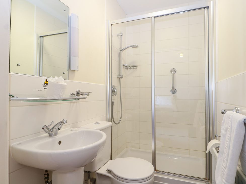 A bathroom with a shower, sink, and toilet at Bedroom 9 in Littlehampton