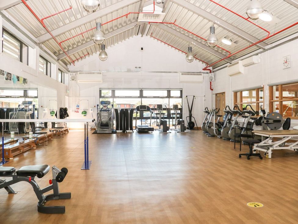 A gym with exercise equipment and windows at Bedroom 9 in Littlehampton