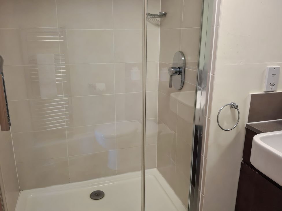 A bathroom with a shower and sink at The Driftwood Dwelling at Marine Court Littlehampton