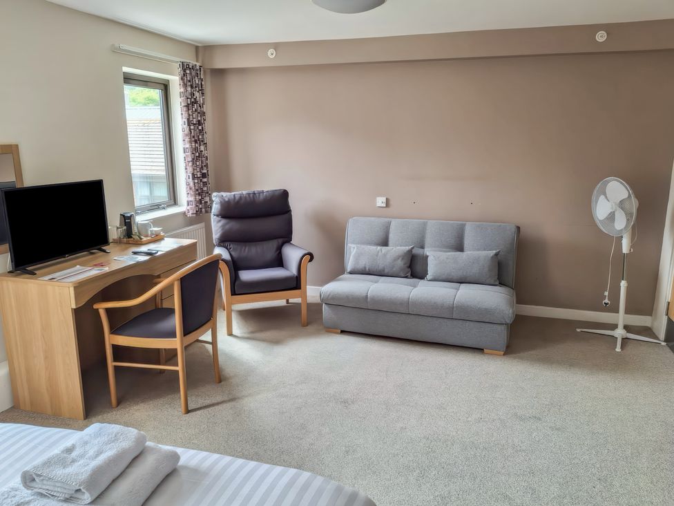A bedroom with a desk and television at The Driftwood Dwelling at Marine Court Littlehampton
