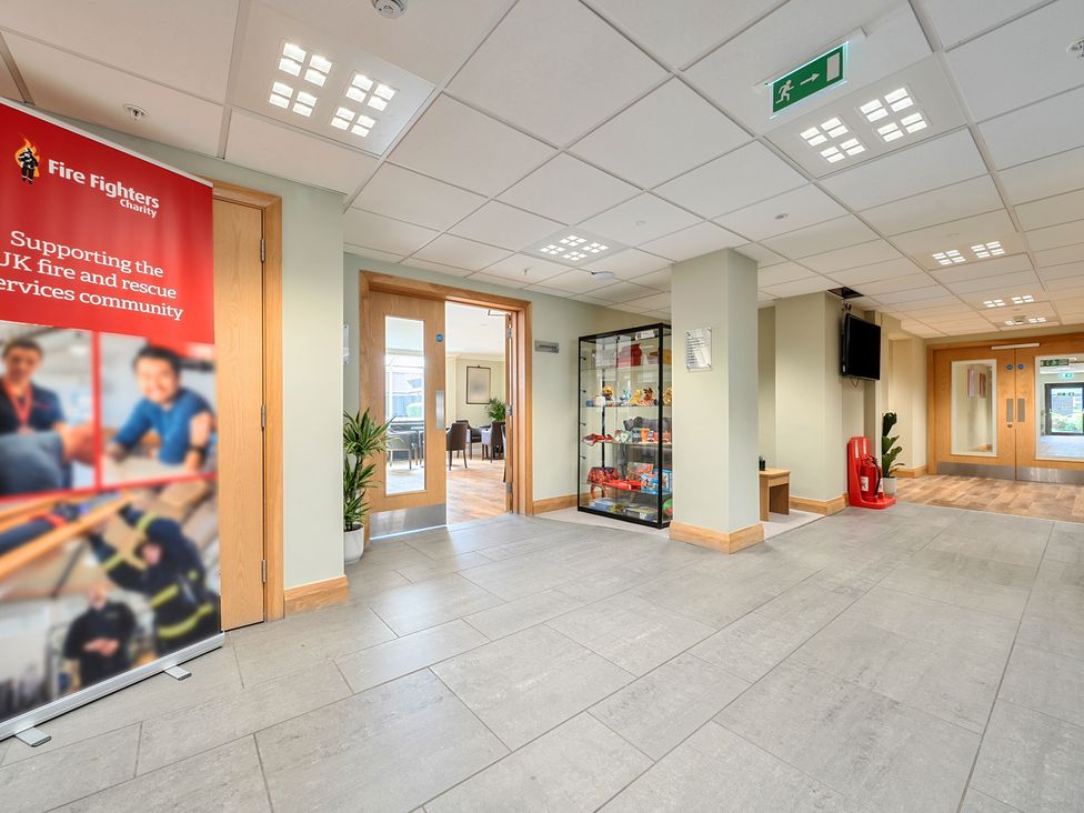 A lobby area with a banner, display case, and seating at Marine Court First-floor Sleeps 3 in Littlehampton