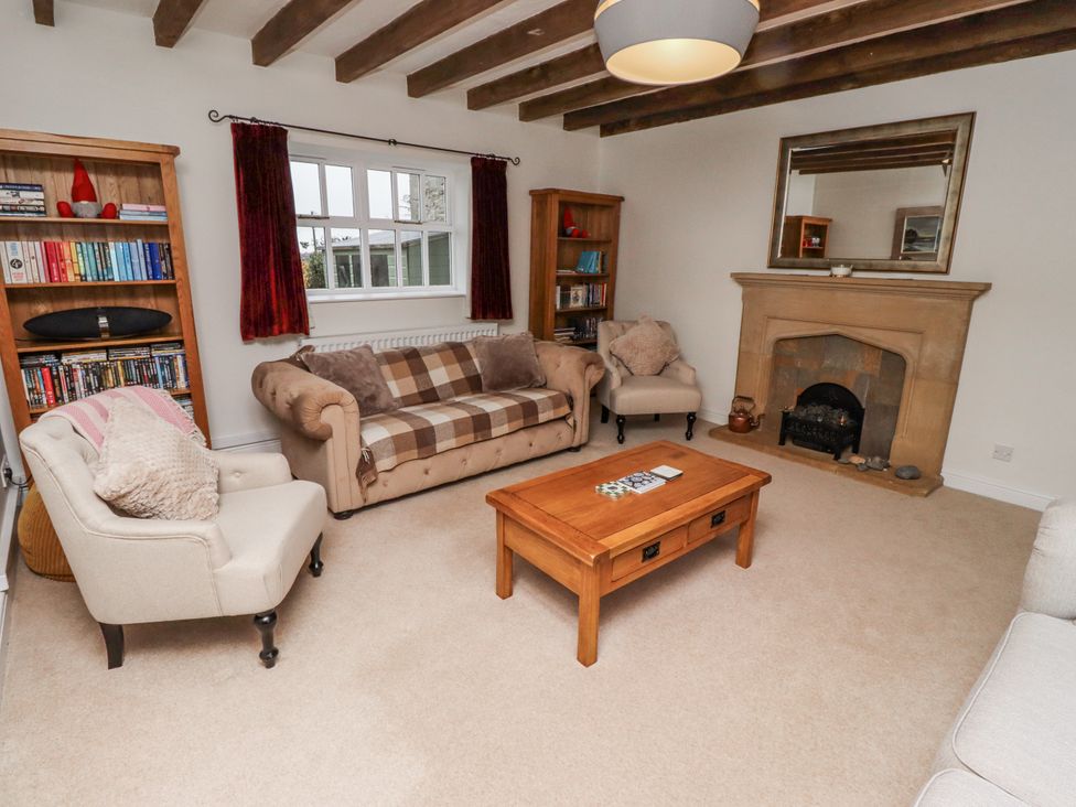 A living room with a sofa, armchairs, and a coffee table at 3 Christon Bank Mews in Alnwick