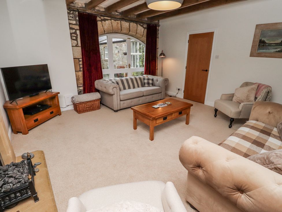 A living room with a sofa and a TV at 3 Christon Bank Mews Alnwick