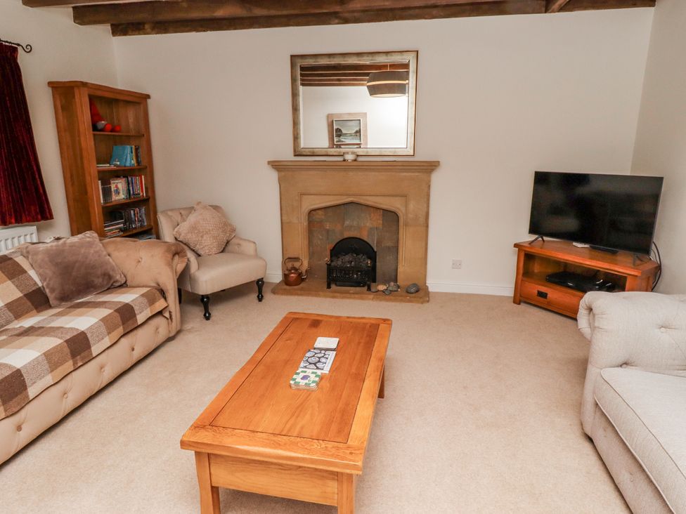 A living room with a fireplace and television at 3 Christon Bank Mews Alnwick