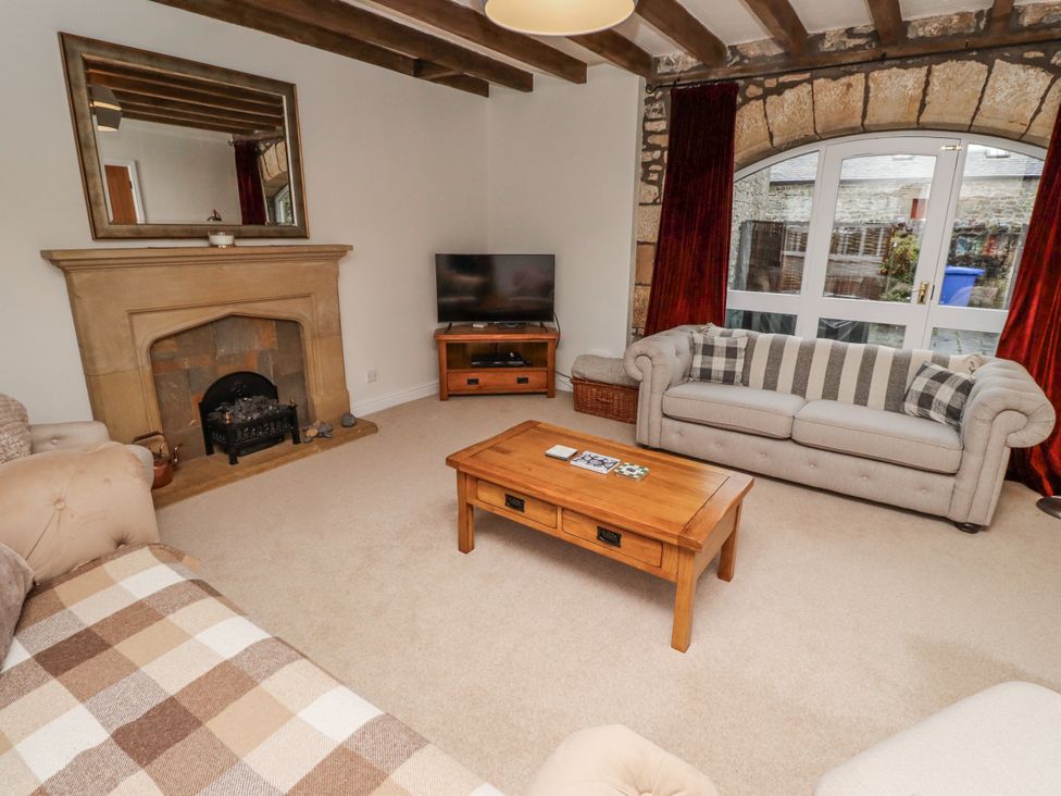 A living room with a coffee table and television at 3 Christon Bank Mews Alnwick