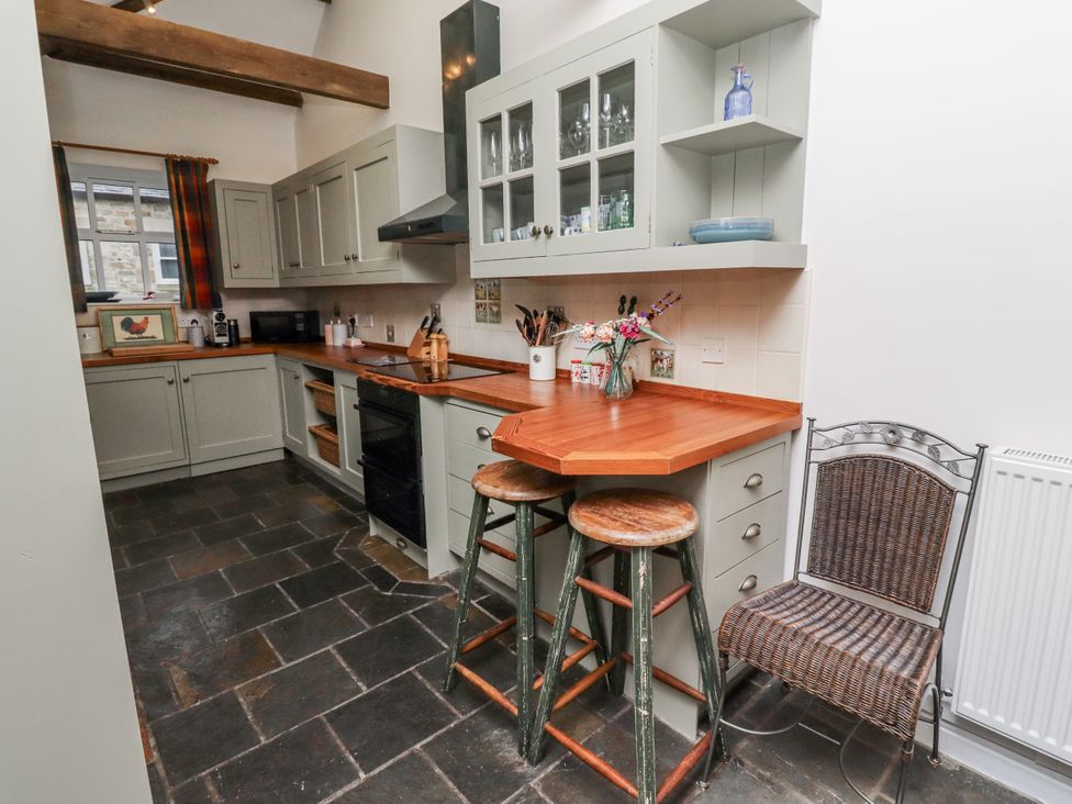 A kitchen with cabinets and a stove at 3 Christon Bank Mews Alnwick