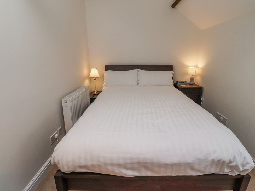 A bedroom with a bed and lamps at 3 Christon Bank Mews in Alnwick