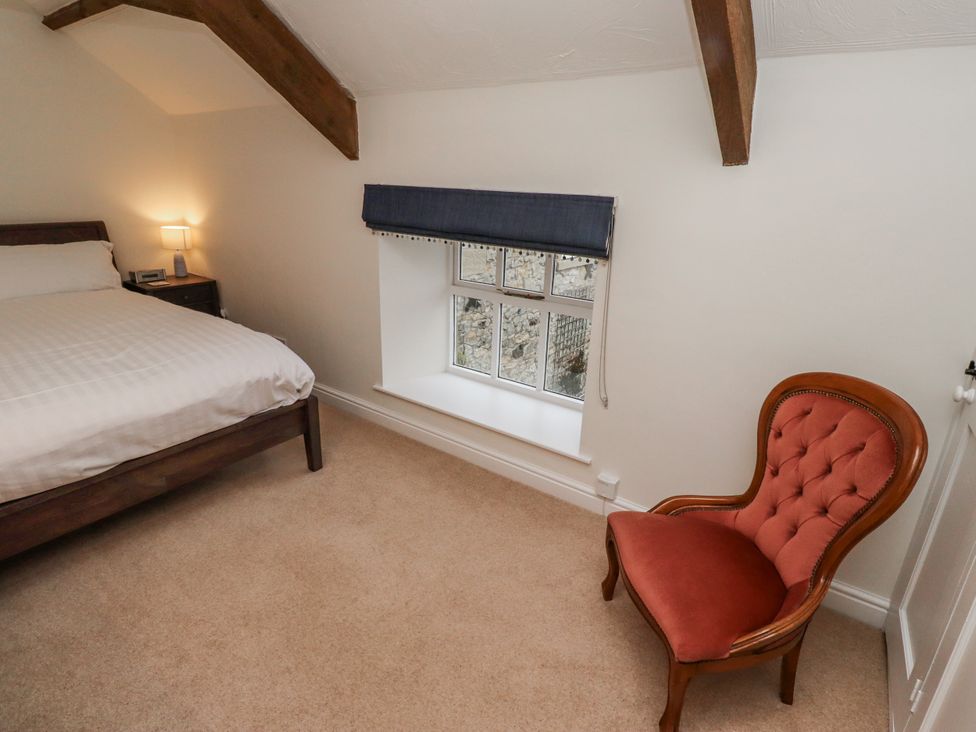 A bedroom with a bed, nightstand, lamp and chair at 3 Christon Bank Mews Alnwick