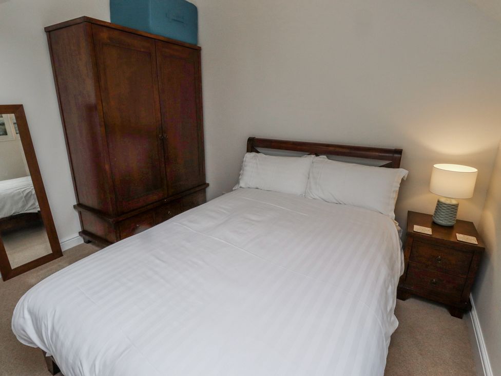 A bedroom with a bed, wardrobe, and lamp at 3 Christon Bank Mews Alnwick