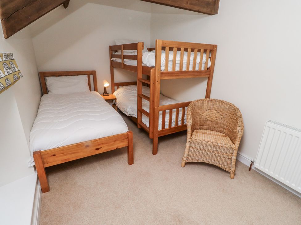 A bedroom with a single bed and a bunk bed at 3 Christon Bank Mews Alnwick